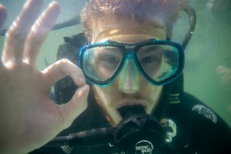 Ein Taucher zeigt unter Wasser das OK-Zeichen